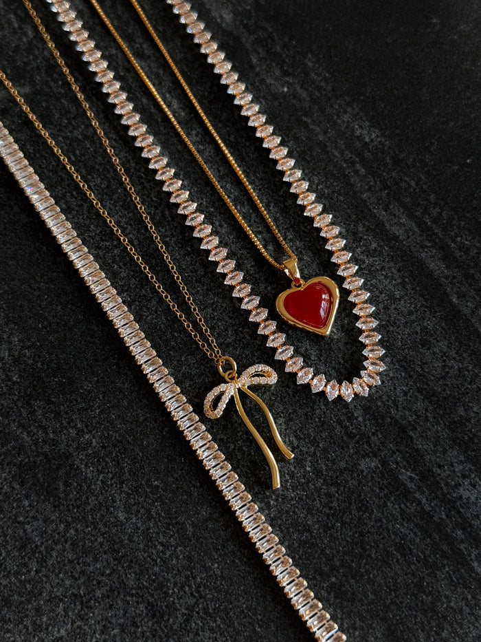 Model wearing the gold Sacred Heart necklace in a campaign shot