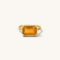 Close up of the Saffron ring with an east-west set gemstone on a white background