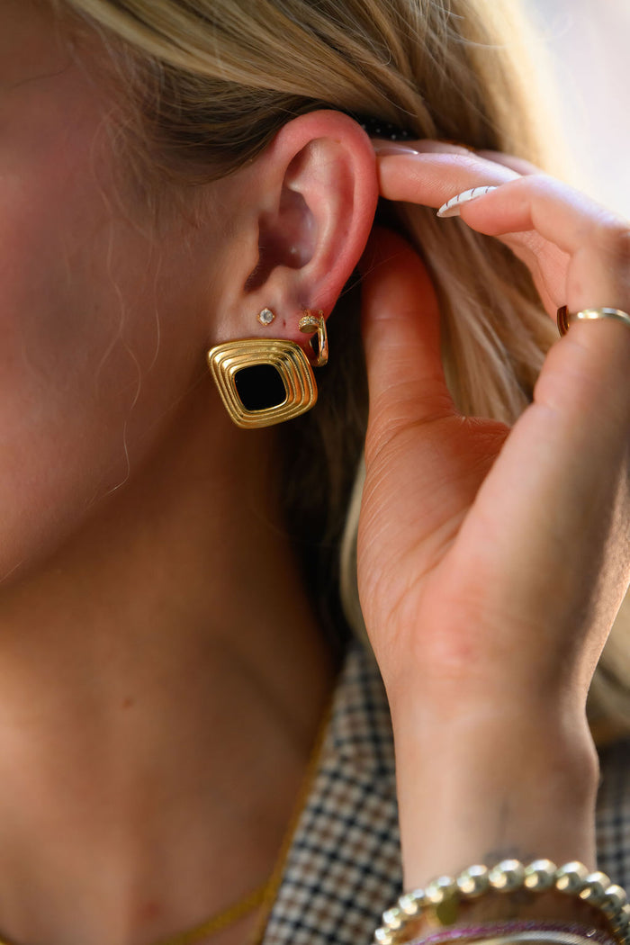 Close up of a woman wearing bold gold earrings