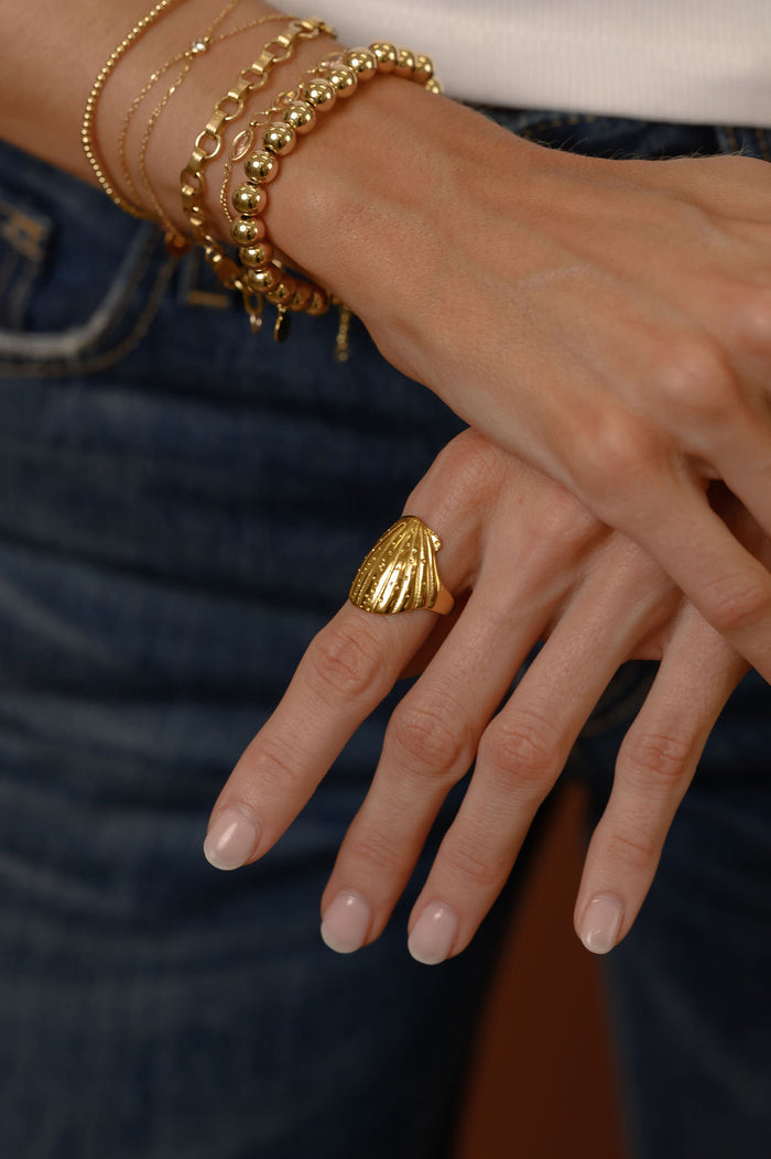 Studio close up of the gold Shelly seashell ring on a white background