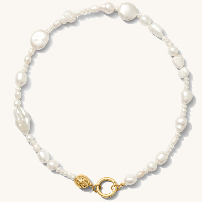 Close up of the gold Sirena baroque pearl necklace on a white background
