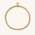 Close up of a gold bead bracelet on a white background