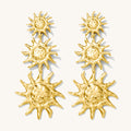 Close up of gold statement earrings on a white background