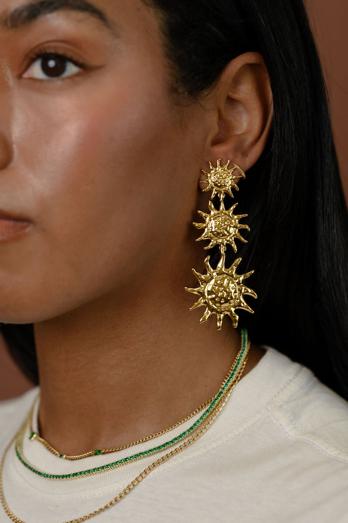 Close up of a woman wearing gold statement earrings