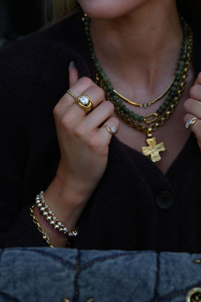 The Love Knot ring, a bold yet delicate gold band with a solitaire stone