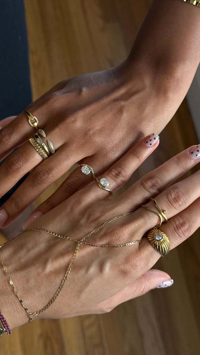 The Solitaire Wave pinky ring in gold, finished with a bright oval solitaire stone