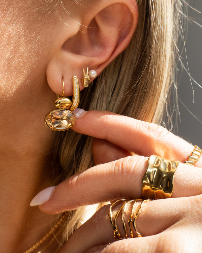 Model wearing the Solstice ring, an open hammered band in gold