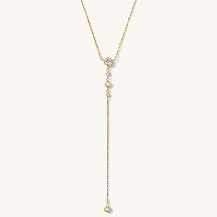 Close up of the Starlight lariat necklace with bezel-set stones on a white background