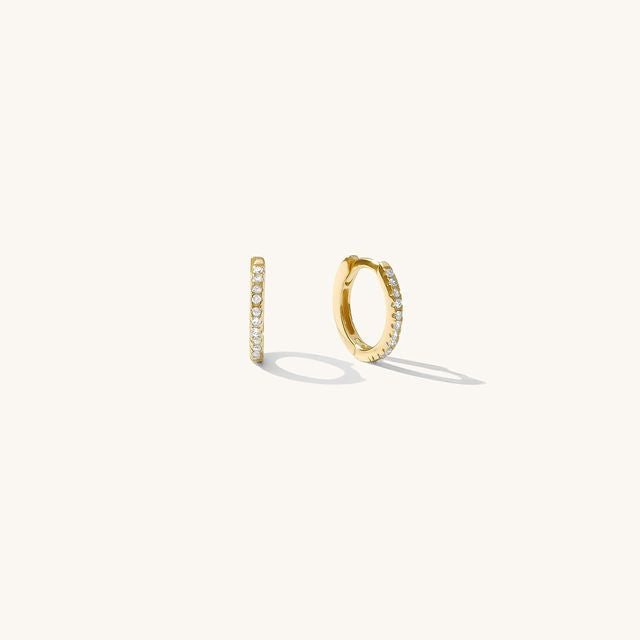 Close up of gold hoops with stones on a white background
