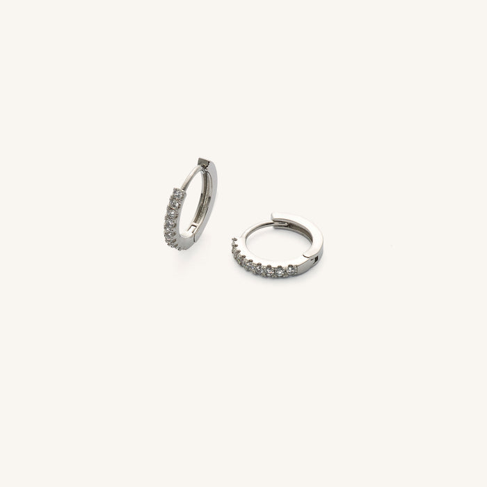 Close up of silver hoops with stones on a white background