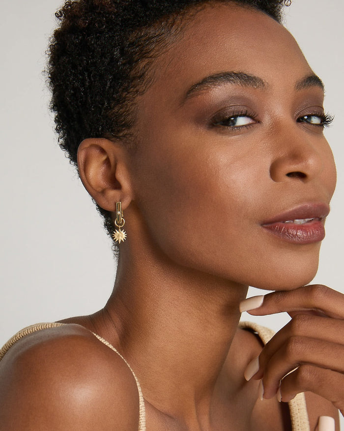 Model wearing Sun Moon & Stars Huggies in 14k gold finish
