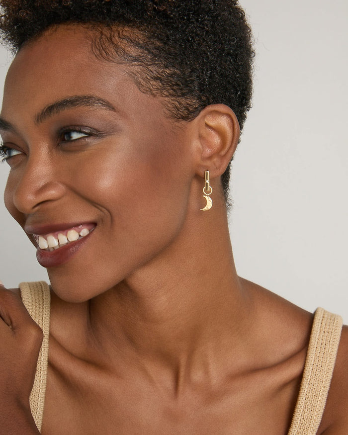 Model wearing Sun Moon & Stars Huggies in 14k gold finish