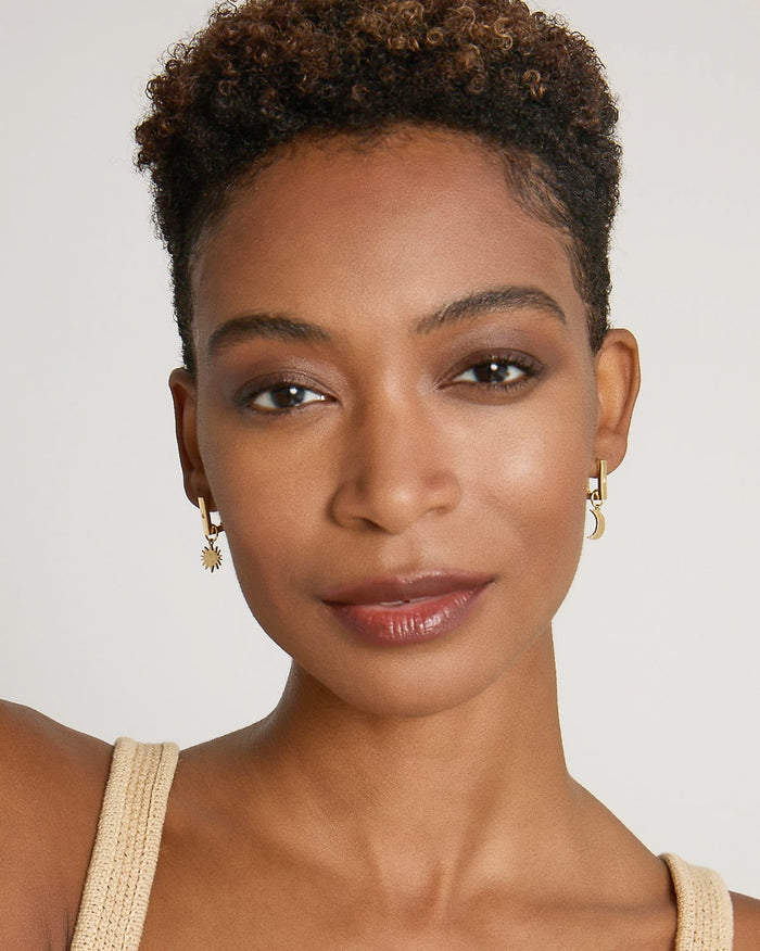 Model wearing Sun Moon & Stars Huggies in 14k gold finish