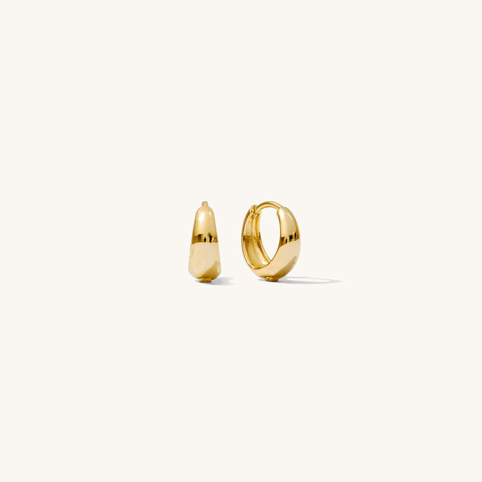 Close up of gold hoop earrings on a white background