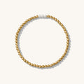 Close up of a gold bead bracelet with silver accent beads on a white background