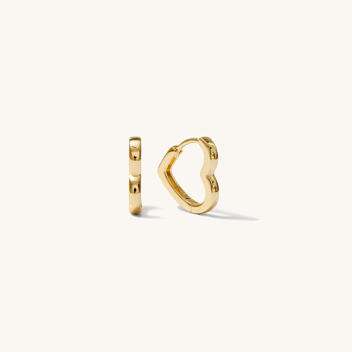 Close up shot of heart shaped hoop earrings on a white background