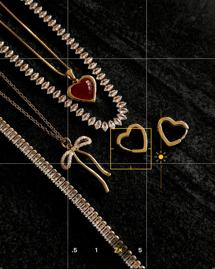 Stone necklaces and hoop earrings on a dark marble background