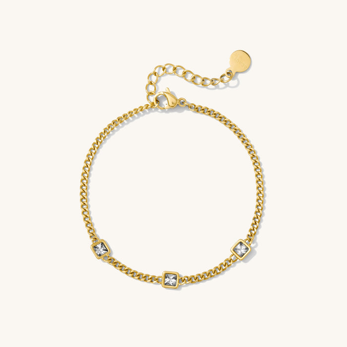 Gold chain bracelet with stones on a white background