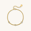 Gold chain bracelet with stones on a white background