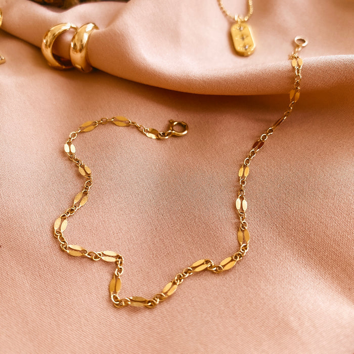 Close up of an ankle wearing the shimmering gold-filled Vica anklet