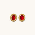 Close up of red and black accent earrings on a white background