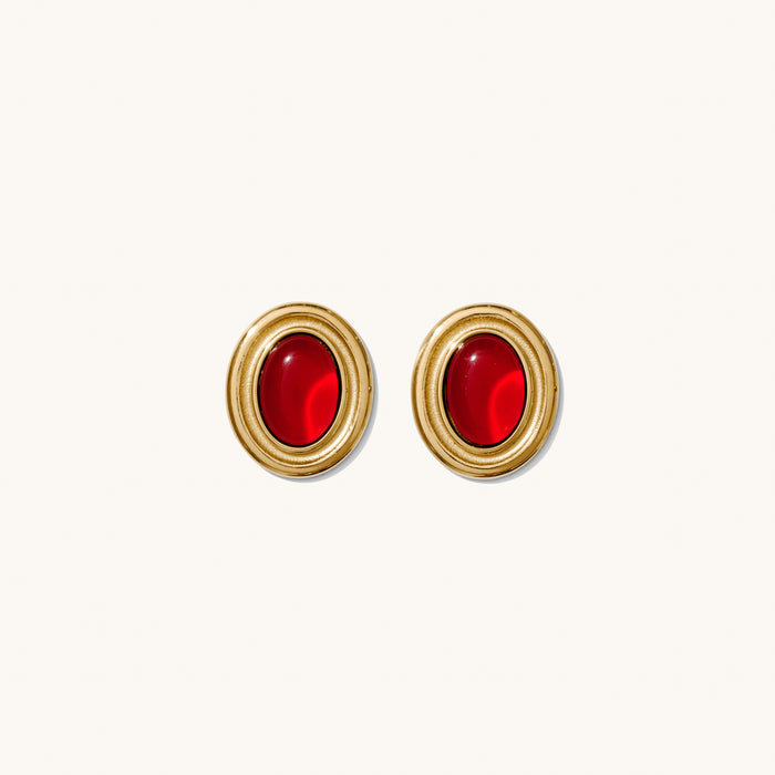 Close up of red and black accent earrings on a white background