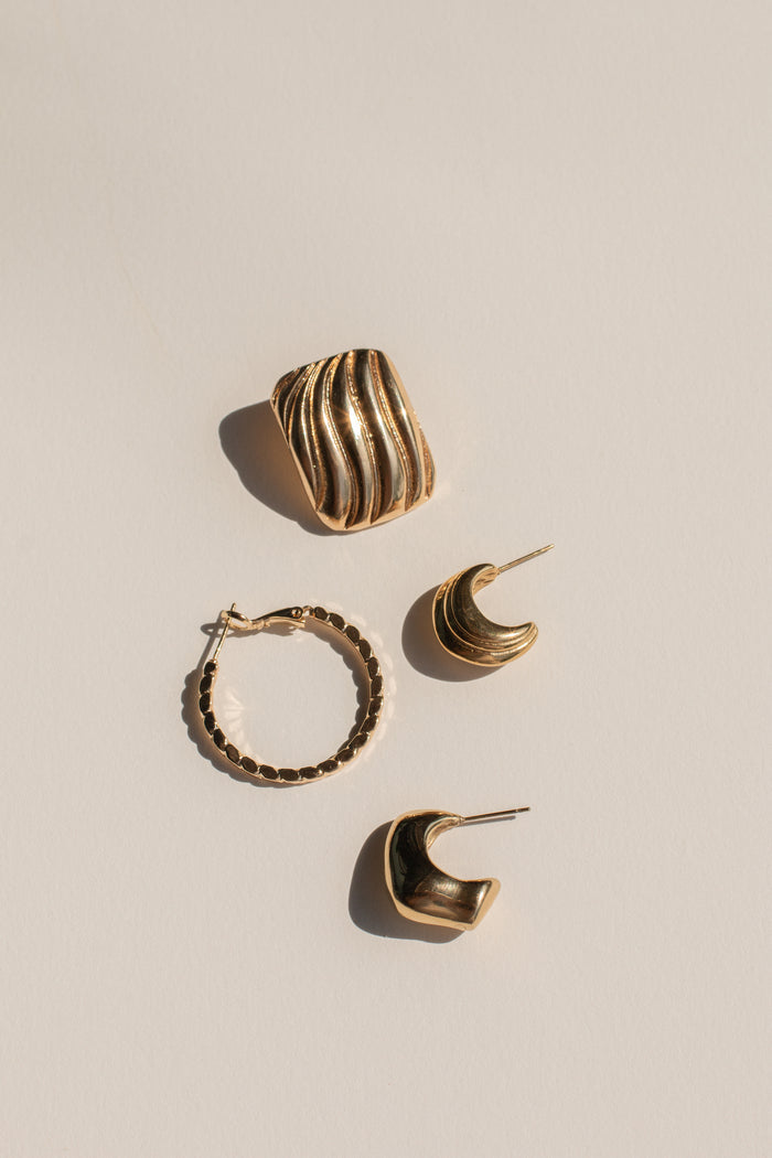 Gold earrings on a neutral background