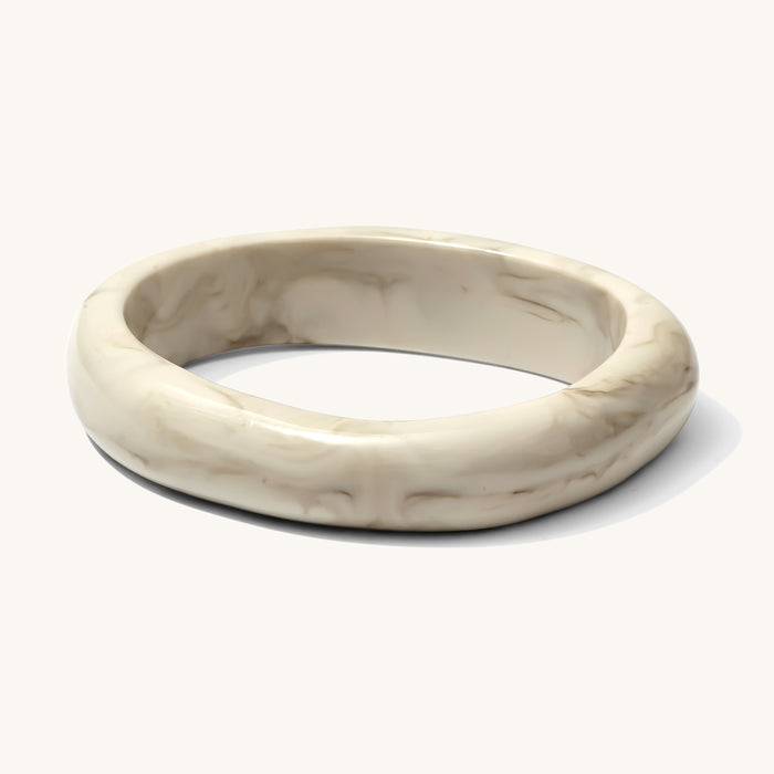 Close up of a warm white resin bracelet on a white background