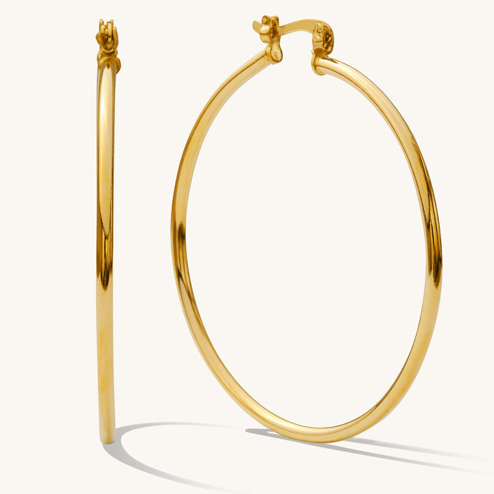 Close up of gold hoops on a white background