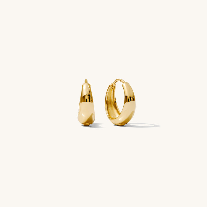 Close up of gold hoop earrings on a white background