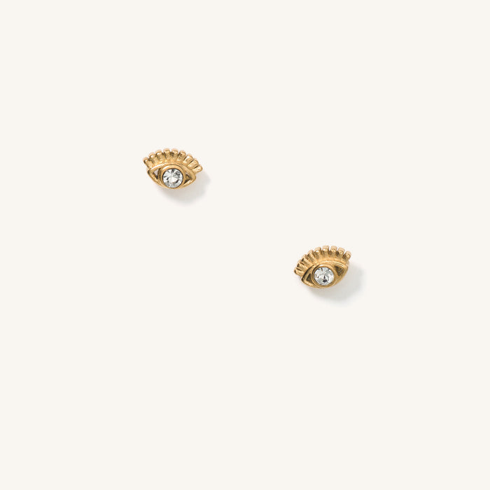 Close up of eye-shaped gold stud earrings on a white background