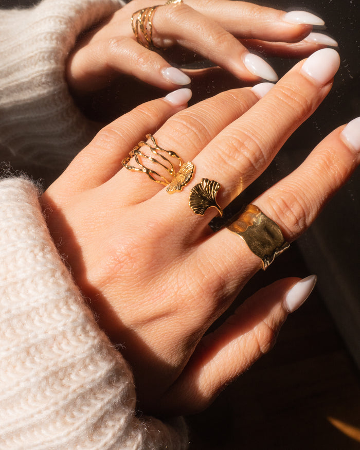 Model wearing the hammered gold Yule cuff ring stacked on the finger