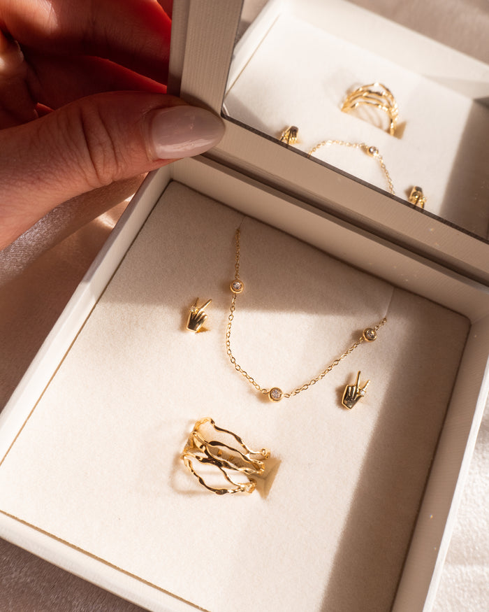 Model wearing the gold Yule ring alongside other stacking rings