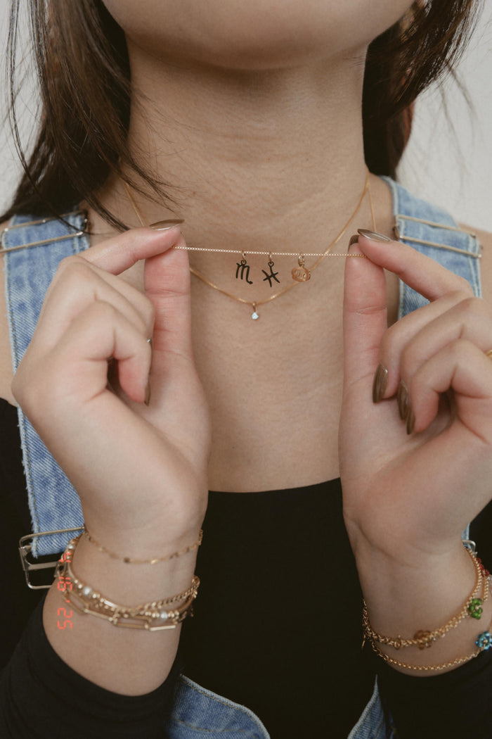 Close view of the gold Zodiac charm necklace from Beads by Tara